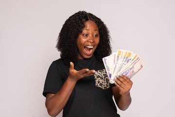 african lady holding money looking surprised