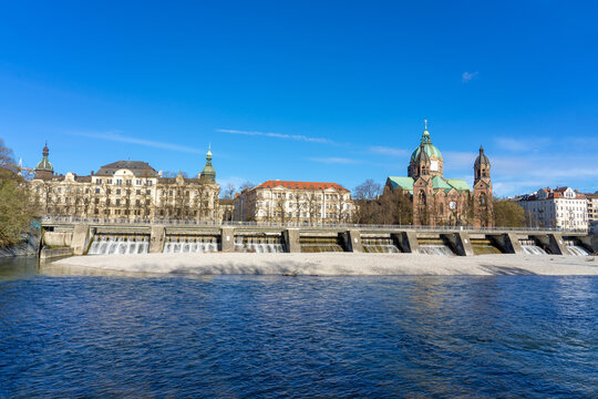 Isar river in Munich with saint Lukas dome cathedral and bridge