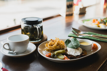 Tasty Breakfast with Wholemeal Bread Toast and Poached Egg with fried onion and spinach and tea on background.