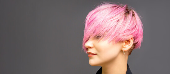 Profile of a beautiful young caucasian woman with short straight bob hairstyle dyed in pink color with closed eyes with copy space