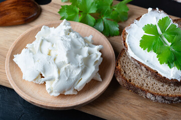 Home made bread on a wooden cutting board with curd cheese and ricotta