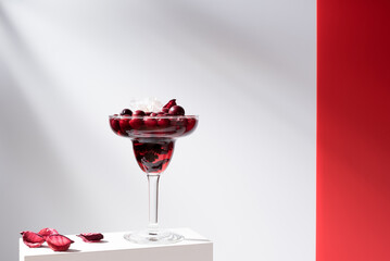 Cóctel Margarita de arándanos rojos sobre un soporte blanco y fondo gris	
