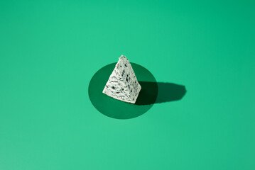 Trozo de queso azul sobre fondo verde