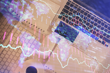 Financial market graph and top view computer on the desktop background. Multi exposure. Investment concept.