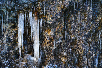 Icicles on the rock. Frozen waterfall in winter.