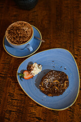 Overhead view of a chocolate and nut cookie with a hot chocolate on a table