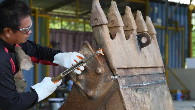 Close-up blacksmith welder in protective mask works with metal steel and iron using a welding machine, bright sparks and flashes in extreme slow motion