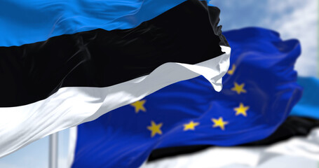 Detail of the national flag of Estonia waving in the wind with blurred european union flag in the background on a clear day