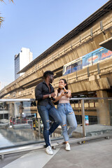 Two multiethnic friends joking while standing outside a mall