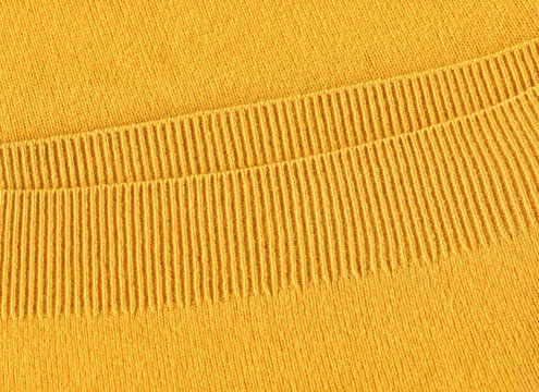 Handmade knitted texture, bright yellow background. Seasonal clothes