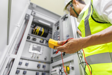 Electrical engineer holding digital multimeter, Electrical engineer is inspecting the electrical system in a factory, energy concept.