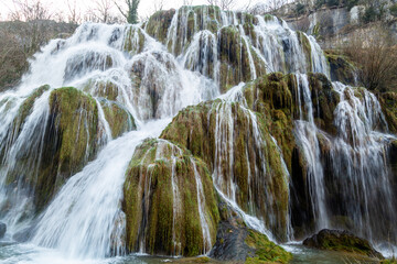 Naklejka premium Les cascades des Tufs au fond de la reculée de Baume-les-Messieurs, dans le Jura, en Bourgogne Franche-Comté, parmi les plus belles cascades de France.