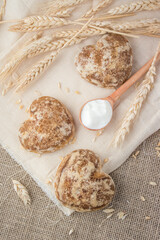 Beautiful heart-shaped gingerbread cookies are arranged with sour cream. Delicious cookies with spikelets