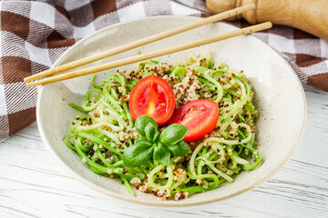 zucchini noodles with quinoa on a white background