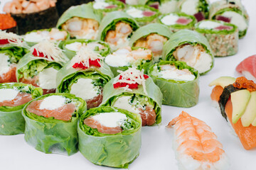 sushi rolls in lettuce with tuna salmon and cheese on a white background. restaurant menu.