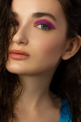 Obraz premium Beautiful brunet model woman face with grey eyes and perfect make-up make smile on camera. Portrait of beauty with nude lips and eyes liner, thick eyesbrow . Female face with clear skin close-up.