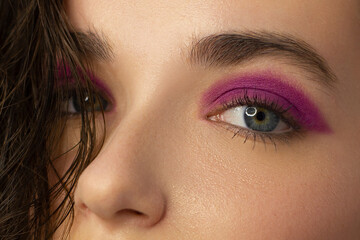 Cosmetics and make-up. Beautiful female eye with sexy pink liner makeup. Fashion big arrow shape on woman's eyelid. Chic evening make-up