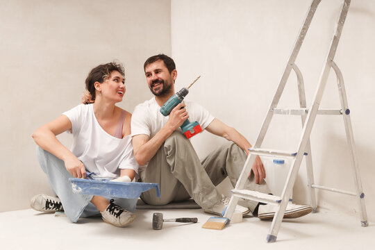 Young happy couple doing apartment repair together themselves