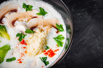 creamy mushroom soup with champignons on a black background