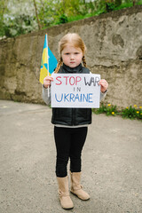 Upset poor toddler girl kid protesting war conflict raises banner with inscription message text...
