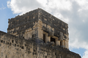 Fototapeta premium Top of the temple on the pok ta pok field, Chichen Itza, Mexico. Place of sacrifice. Temple of the Beared Man against the background of a cloudy sky.