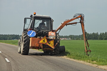 Wheeled tractor lawnmover with a external detachable hydraulic mounted mower equipment mowing the...