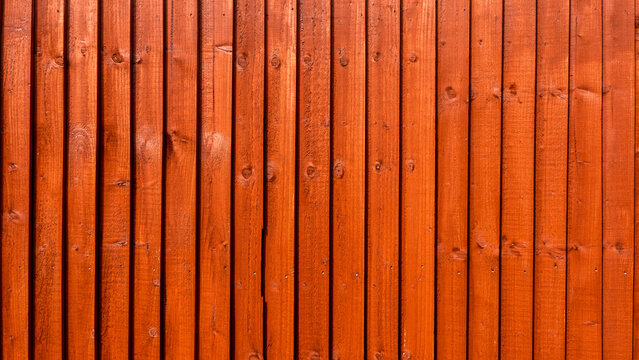 Wooden fence treated with water-based red cedar paint