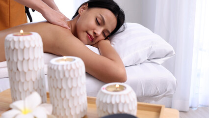 Obraz na płótnie Canvas Young Asian woman enjoying with back massage in spa salon