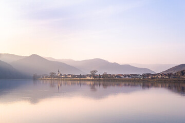 sunrise over mountains and river with reflection in water