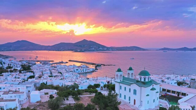Greek island Paros sunset aerial view. Sun rays through sky clouds and calm sea