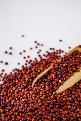 red quinoa seeds on a white acrylic background