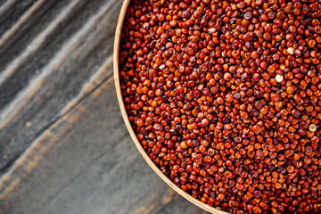 red quinoa seeds on a dark rustic background