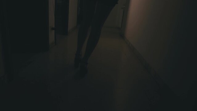 detail of the legs of young woman walking along the corridor staggering