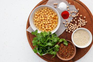 Ingredients for falafel. Chickpeas, herbs, spices, sesame seeds in bowls. Concept for middle eastern, Arabic cuisine, restaurants, menus, healthy, vegetarian and vegan lifestyle. Copy space, top view