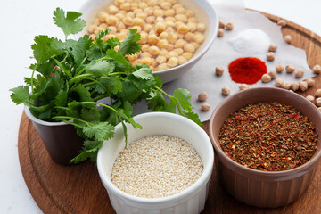 Ingredients for falafel. Chickpeas, herbs, spices, sesame seeds in bowls. Concept for middle eastern, Arabic cuisine, restaurants, menus, healthy, vegetarian and vegan lifestyle 