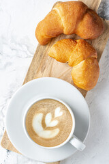 Morning coffee with croissant. Light breakfast. The atmosphere of an early calm morning.