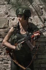 Military girl in uniform near a stone wall during the day. Portrait