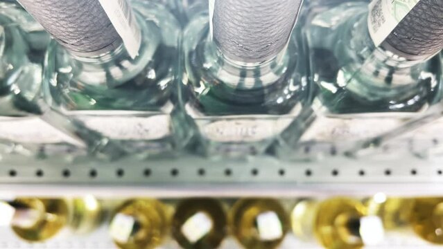 Rows of vodka bottles stand on the shelves of a liquor store (ABC store). Top view. Closeup
