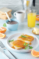 Sandwiches with marmalade, orange juice and coffee ready for breakfast