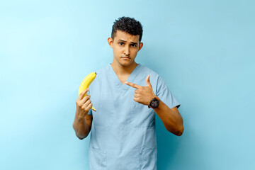 Latin American male urology specialist holding a banana, male organ and prostate concept.