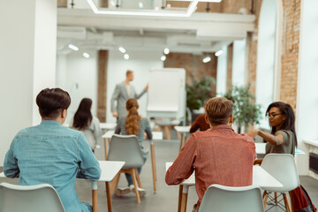 Lecturer standing near flipchart during lecture to students