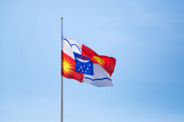 Coat of arms of Sochi against the blue sky. Russia, Krasnodar Territory, Sochi. Flag with the coat of arms of Sochi in the wind.