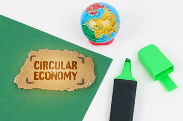 On the table is a globe and a marker, on a green background there is a cardboard with the...