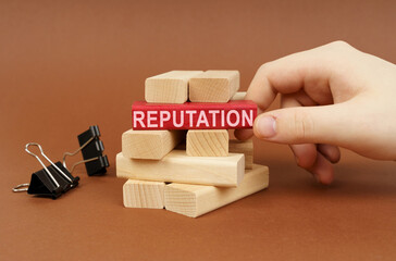 Clamps and wooden blocks lie on a brown surface, a person takes out a red block with the...