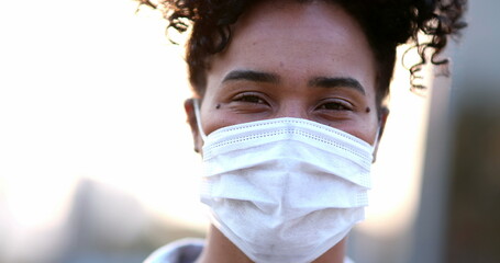 Young African black woman putting covid-19 face mask outside