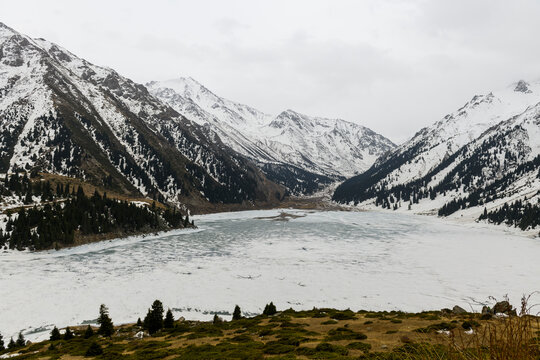 Beautiful mountain lake with ice and snow. Big Almaty lake in winter time. Kazakhstan.
