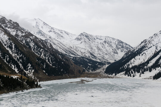 Beautiful mountain lake with ice and snow. Big Almaty lake in winter time. Kazakhstan.