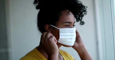 Young African American woman putting face mask