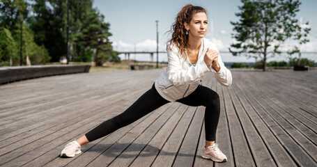 Female athlete outdoor training stretching of all muscle groups