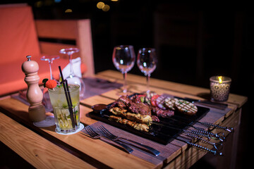 A plate of Chicken and beef BBQ with grilled tomatoes, potatoes and onions 